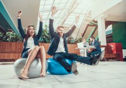 ofis egzersizleri yapmak için pilates topları üzerinde duran kadın ve erkek ofis çalışanı