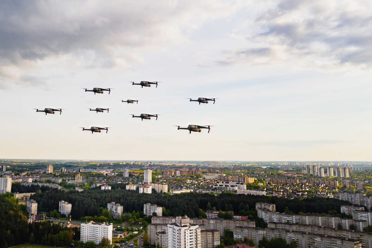 şehirde gökyüzünde uçan drone sürüsü