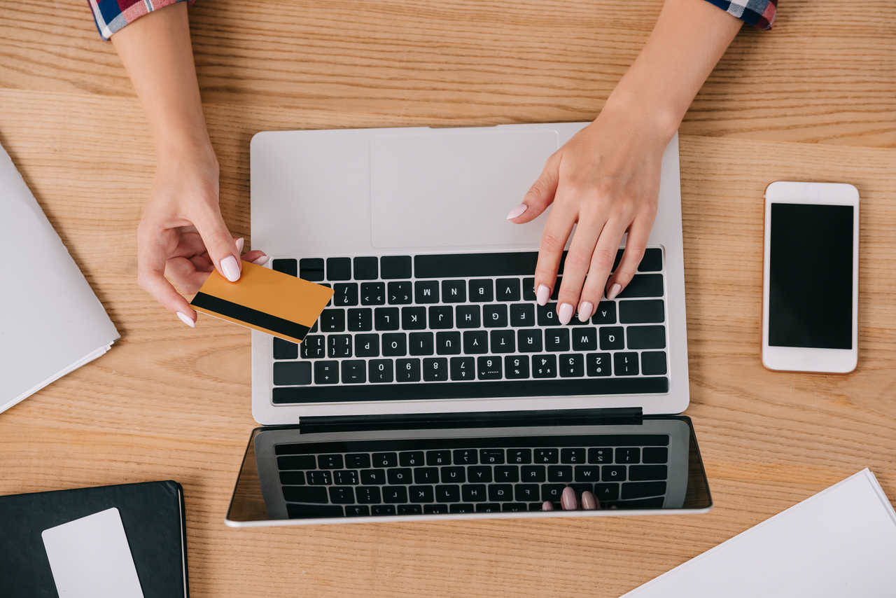 kredi kartı ile bilgisayar üzerinden online alışveriş yapan kadın